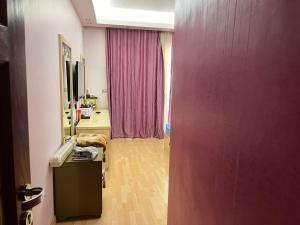 een kamer met een paarse muur en een kamer met een bureau bij Sunterra in Sharm El Sheikh