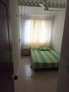 Dormitorio pequeño con cama y ventana en Casa para disfrutar unos días en familia, en Girardot