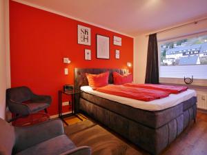a bedroom with a bed and a red wall at Upland Apartments - Fewo Zeitgeist (inkl. MeineCardPlus) in Willingen