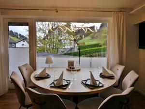 a dining room with a table and chairs and a large window at Upland Apartments - Fewo Zeitgeist (inkl. MeineCardPlus) in Willingen
