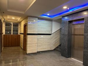 a lobby with a elevator and a wall of tiles at NP Royal INN in Bangalore