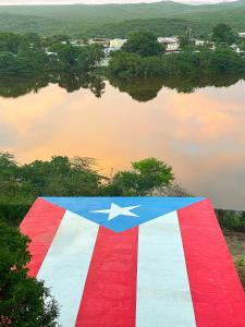an american flag with a lake in the background at Palmeras Beach Apartments - Playa Santa in Guanica