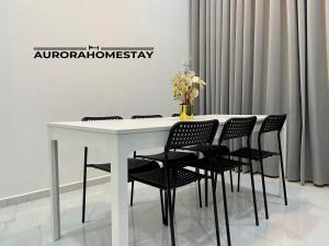 een witte tafel met zwarte stoelen in een kamer bij Aurora Homes in Marang
