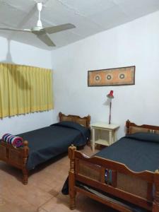 sypialnia z 2 łóżkami i wentylatorem sufitowym w obiekcie Quinta campestre Amor Secreto. Alojamiento entero en renta w mieście Temixco