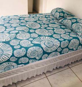 una cama con un patrón azul y blanco en ella en Pousada da Sú en Bertioga