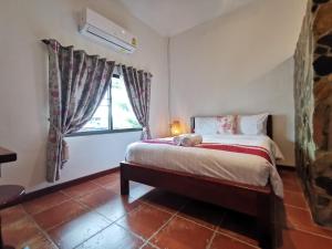 a bedroom with a bed and a window at Sri Ayuttaya Guesthouse in Bangkok