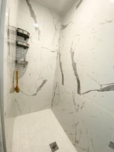 - une salle de bains blanche avec un mur en marbre blanc dans l'établissement Beautiful Walk out Basement Apartment in Pickering near Beach, à Pickering