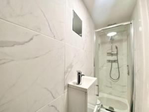 a white bathroom with a shower and a toilet at House 1905 - Self Catering Serviced Apartment in North Tidworth