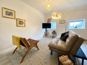 uma sala de estar com um sofá e uma cadeira em House 1905 - Self Catering Serviced Apartment em North Tidworth