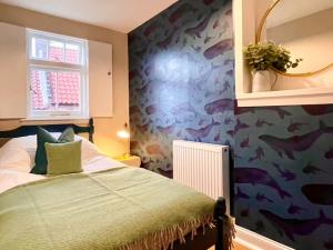 a bedroom with a bed with a fish themed wall at Neuk Hoose in Crail