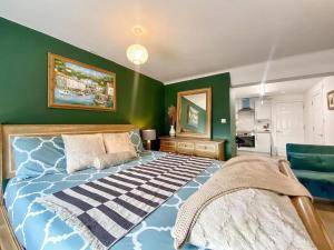 um quarto com uma cama e uma parede verde em House 1905 - Self Catering Serviced Apartment em North Tidworth