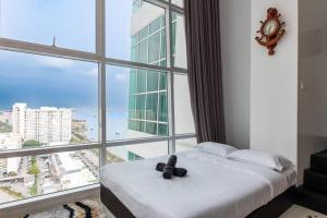 a bed in a room with a large window at 2Bedrooms Maritime Luxury Seaview Suite 2-10pax in Jelutong