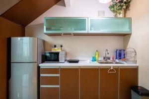 a kitchen with a refrigerator and a microwave at 2Bedrooms Maritime Luxury Seaview Suite 2-10pax in Jelutong