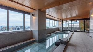 a swimming pool in a building with windows at Tenseien Odawara Station Annex in Odawara