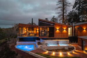 ein Haus mit Pool davor in der Unterkunft Sequoia Lodge in Crafers