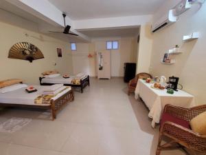 Großes Zimmer mit 2 Betten und Tischen. in der Unterkunft Sandy beach hotel in Thiruvananthapuram
