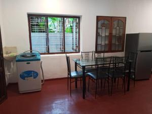 ein Esszimmer mit Tisch und Stühlen und einem Fenster in der Unterkunft Villa Arunodaya in Hikkaduwa + 9 Fotos