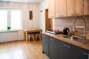 a kitchen with a sink and a table with a window at Przystań in Stalowa Wola