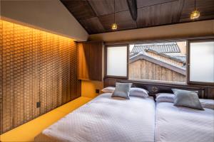 a bedroom with two beds and a window at GION KAWASEMI in Kyoto