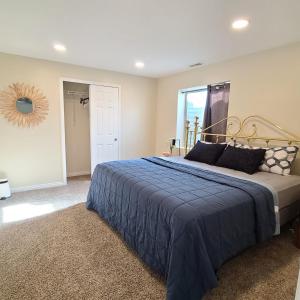 um quarto com uma cama grande e um cobertor azul em Entire Cozy Basement! Private Entrance! - Fast Wifi! em Salt Lake City
