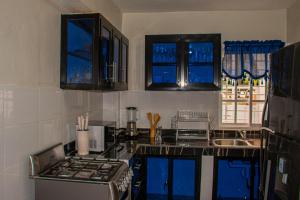 a kitchen with blue windows and a counter top at D' Yoko Village's in Pedernales