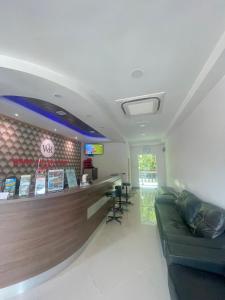 a waiting room with a couch and a bar at Wang Valley Resort in Pantai Cenang