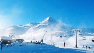 a snow covered mountain with people on a ski lift at studio Batlou ménage inclus in Arette