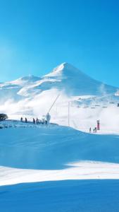 a group of people standing on a snow covered mountain at studio Loubat pyrénée, ménage inclus in Arette