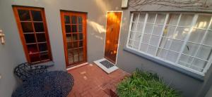 a patio with a table and chairs in front of a house at Cozy 1 Bedroom Cottage in Johannesburg