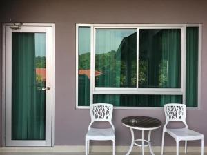 珍南海灘的住宿－王谷度假酒店，窗前的两把椅子和一张桌子