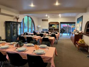 Riverbank Park MOTEL في برايت: غرفة طعام مع طاولات وكراسي في مطعم