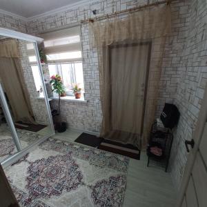 a bathroom with a shower with a brick wall at Hotel "Тихий Дом Трансфер" in Bishkek