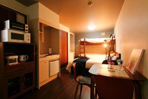 une chambre d'hôtel avec un lit, une table et une cuisine dans l'établissement HEIGHTS N7, à Kita-rokujō