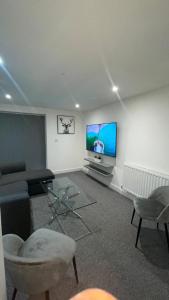 a living room with a couch and a tv on a wall at 2 bed room luxury apartment in old Kent road London in London