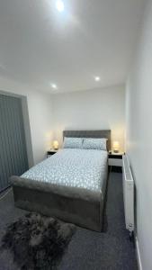 a bedroom with a bed and two tables with lamps at 2 bed room luxury apartment in old Kent road London in London