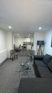 a living room with a couch and chairs and a kitchen at 2 bed room luxury apartment in old Kent road London in London