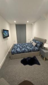 a bedroom with a bed with a blue comforter at 2 bed room luxury apartment in old Kent road London in London