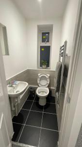 a bathroom with a white toilet and a sink at 2 bed room luxury apartment in old Kent road London in London