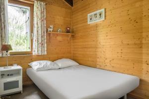 ベットマーアルプにあるMinerva Antaresの木製の壁に白いベッドが備わるベッドルーム1室