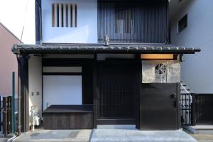 een toegang tot een gebouw met een zwarte deur bij Kyo no oozora KIHANA in Kyoto