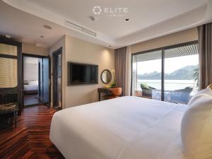 a bedroom with a large white bed and a television at Elite of the Seas in Ha Long