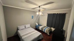 1 dormitorio con 2 camas y ventilador de techo en Balcones De Capital en Vendimia en Mendoza