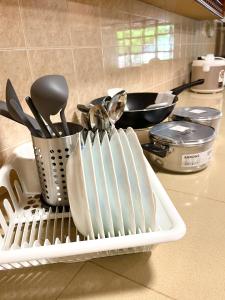 a white dish rack with utensils on a kitchen counter at Villa Ruby - with private swimming pool in Kota Bharu