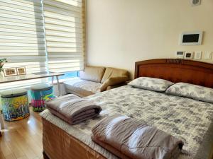 a bedroom with a bed and a couch at DG House in Daegu