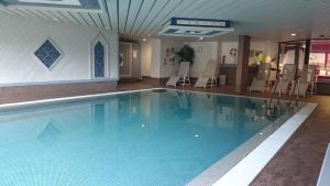 a large swimming pool with chairs in a building at Erholung pur bieten Schwarzwaldoase und Murgidylle in Baiersbronn