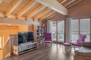 ベットマーアルプにあるAarninkhofのリビングルーム(薄型テレビ、紫色の椅子付)