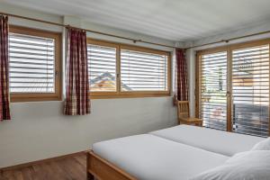 1 dormitorio con 2 camas y ventana en Aarninkhof, en Bettmeralp