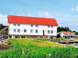 un edificio blanco con techo rojo en una colina en Holiday home bremnes III, en Bremnes