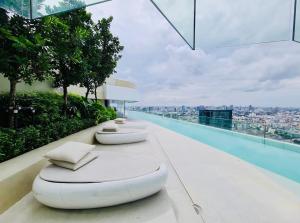 a row of beds sitting on the edge of a building at Asok - Din Daeng Apartment in Bangkok