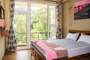 ein Schlafzimmer mit einem Bett und einem großen Fenster in der Unterkunft Maple View in Udagamandalam